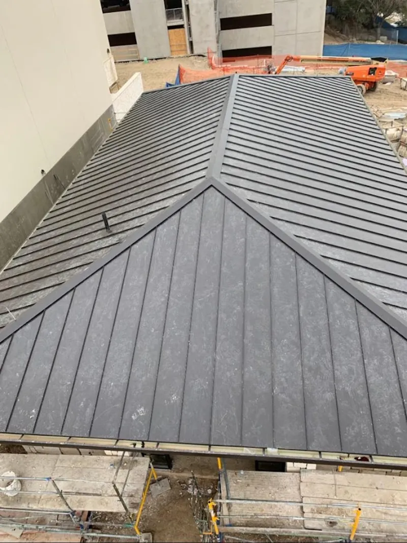Commercial metal roof construction with crane equipment in Nantucket